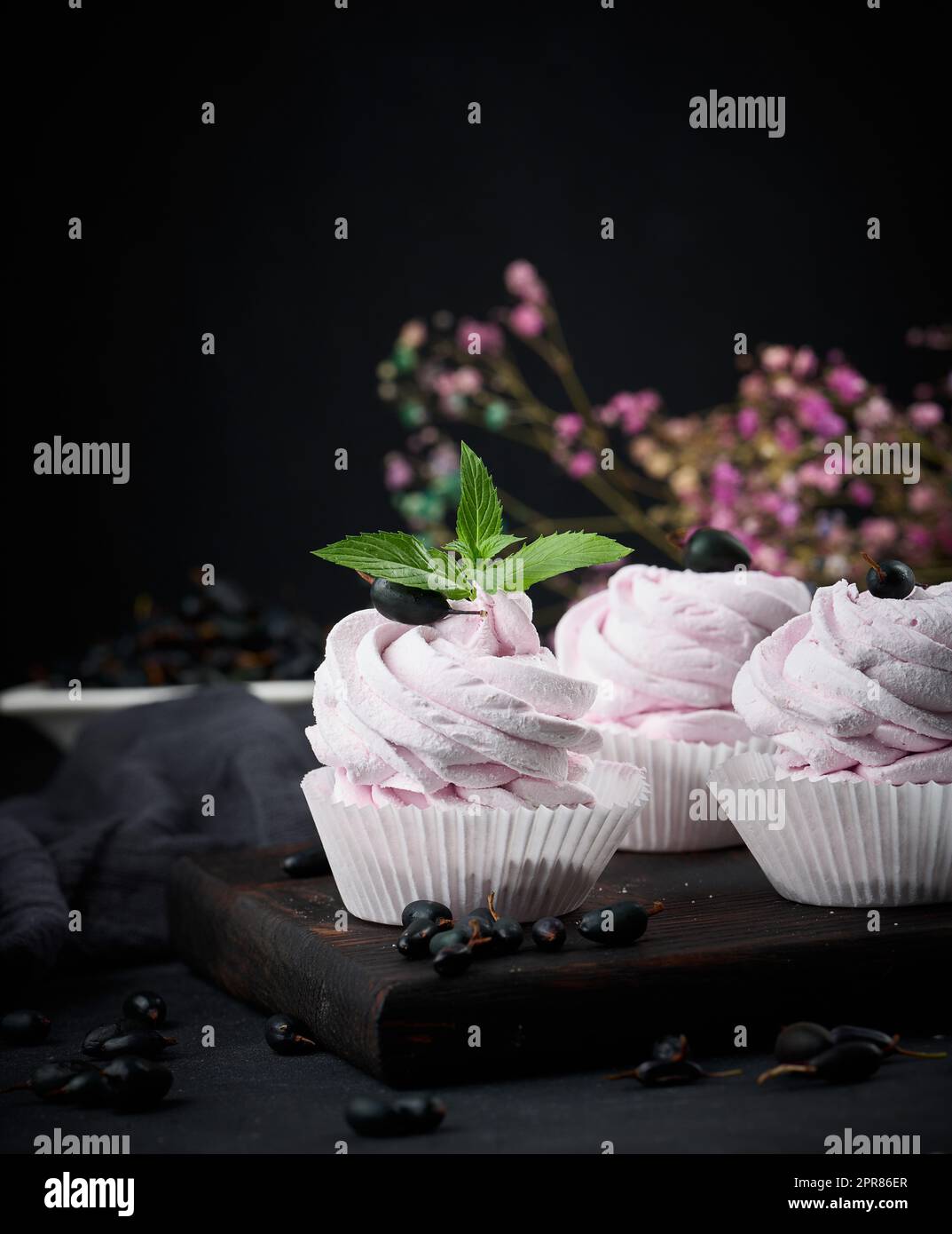 Marshmallows aux fruits martionnés dans une tasse en papier sur un plateau en bois noir, délicieux dessert Banque D'Images