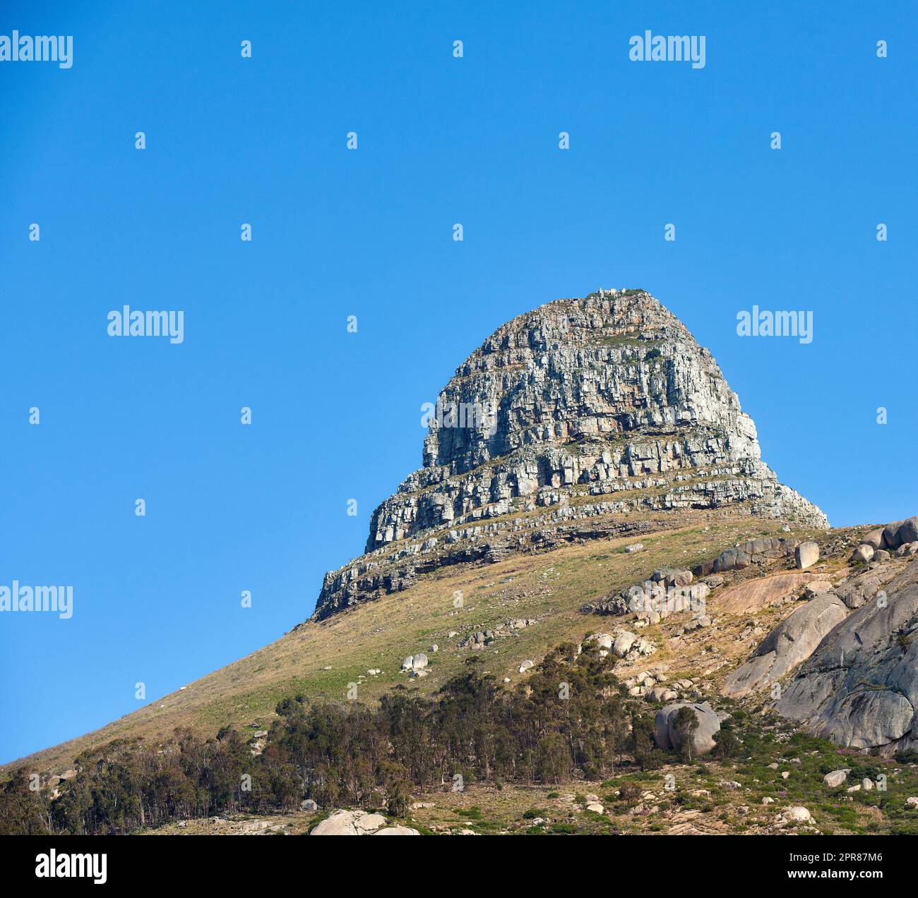 Paysage de la montagne de la tête des Lions sur un ciel bleu clair avec espace de copie. Pic de montagne des Rocheuses avec collines ondulantes couvertes d'arbres et de buissons près de l'emplacement populaire de randonnée dans le Cap, Afrique du Sud Banque D'Images