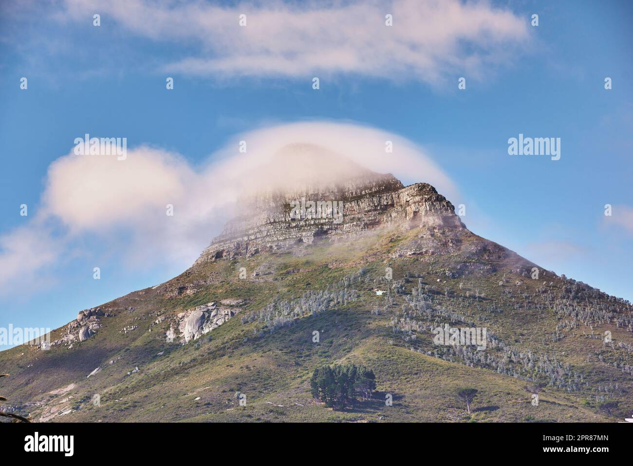 Vue sur le paysage de la montagne de Lions Head avec des nuages couvrant le sommet contre un ciel bleu et un espace de copie au Cap, en Afrique du Sud. Terrain de randonnée sauvage et accidenté dans la destination touristique populaire et la nature Banque D'Images