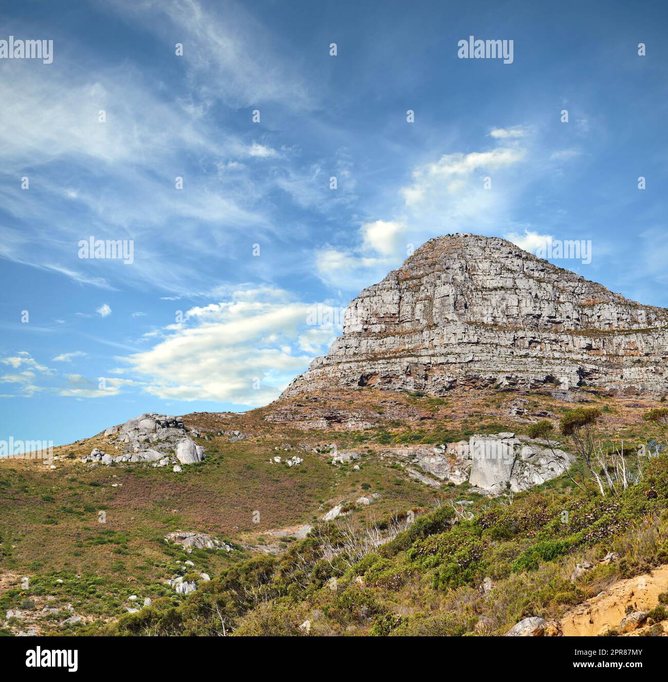Vue sur le paysage de la montagne de Lions Head avec des nuages couvrant le sommet contre un ciel bleu et un espace de copie au Cap, en Afrique du Sud. Terrain de randonnée sauvage et accidenté dans la destination touristique populaire et la nature Banque D'Images
