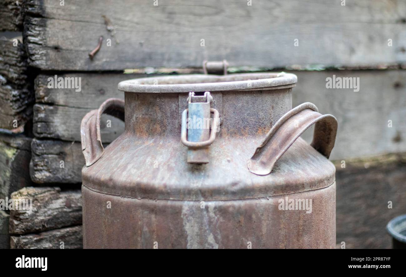 Une vieille boîte en métal rouillé dans la campagne. Récipient pour le transport de liquides, de lait ou de combustibles liquides avec plusieurs poignées. Banque de lait de forme cylindrique à col large. Flacon avec bouchon scellé. Banque D'Images