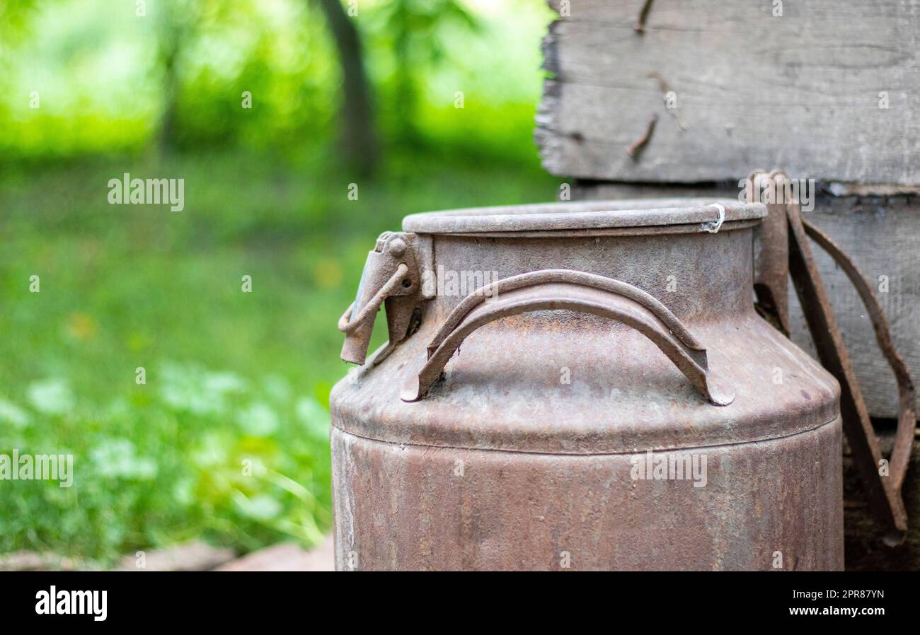 Une vieille boîte en métal rouillé dans la campagne. Récipient pour le transport de liquides, de lait ou de combustibles liquides avec plusieurs poignées. Banque de lait de forme cylindrique à col large. Flacon avec bouchon scellé. Banque D'Images