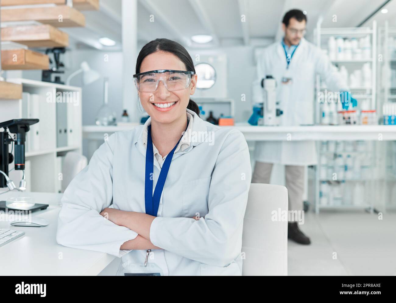 La science est le monde dans lequel j'aime me perdre. Portrait d'un jeune scientifique assis avec ses bras croisés dans un laboratoire. Banque D'Images