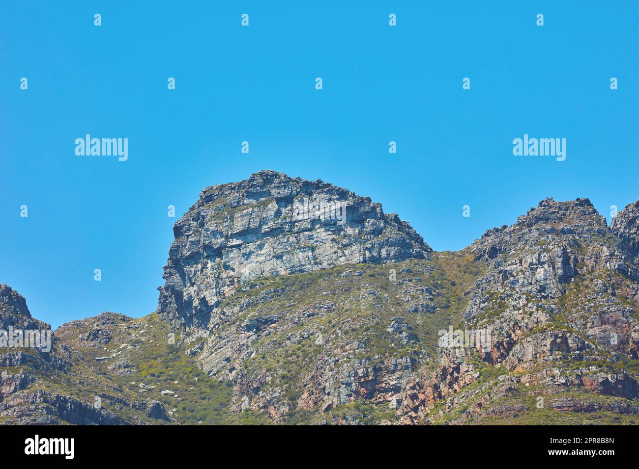 Paysage pittoresque des douze Apôtres montagne sous ciel bleu clair copie espace au Cap, Afrique du Sud. Destination touristique et touristique célèbre avec terrain de randonnée escarpé et arbres et arbustes en pleine croissance Banque D'Images