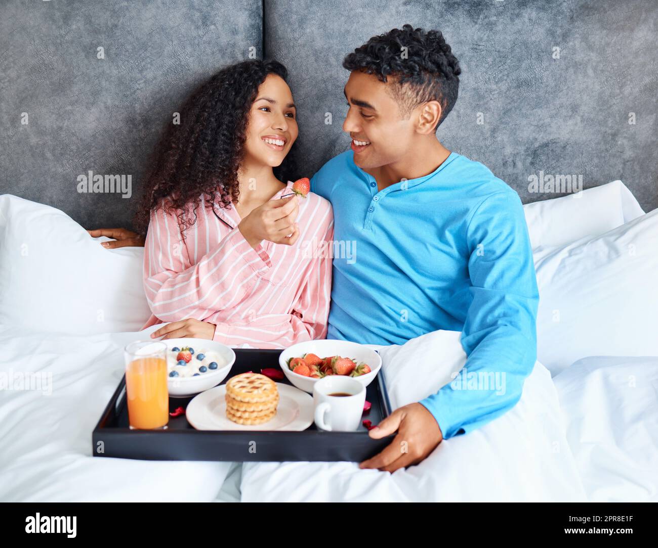 C'est le meilleur. Un jeune couple affectueux qui profite d'un petit déjeuner sain au lit ensemble. Banque D'Images