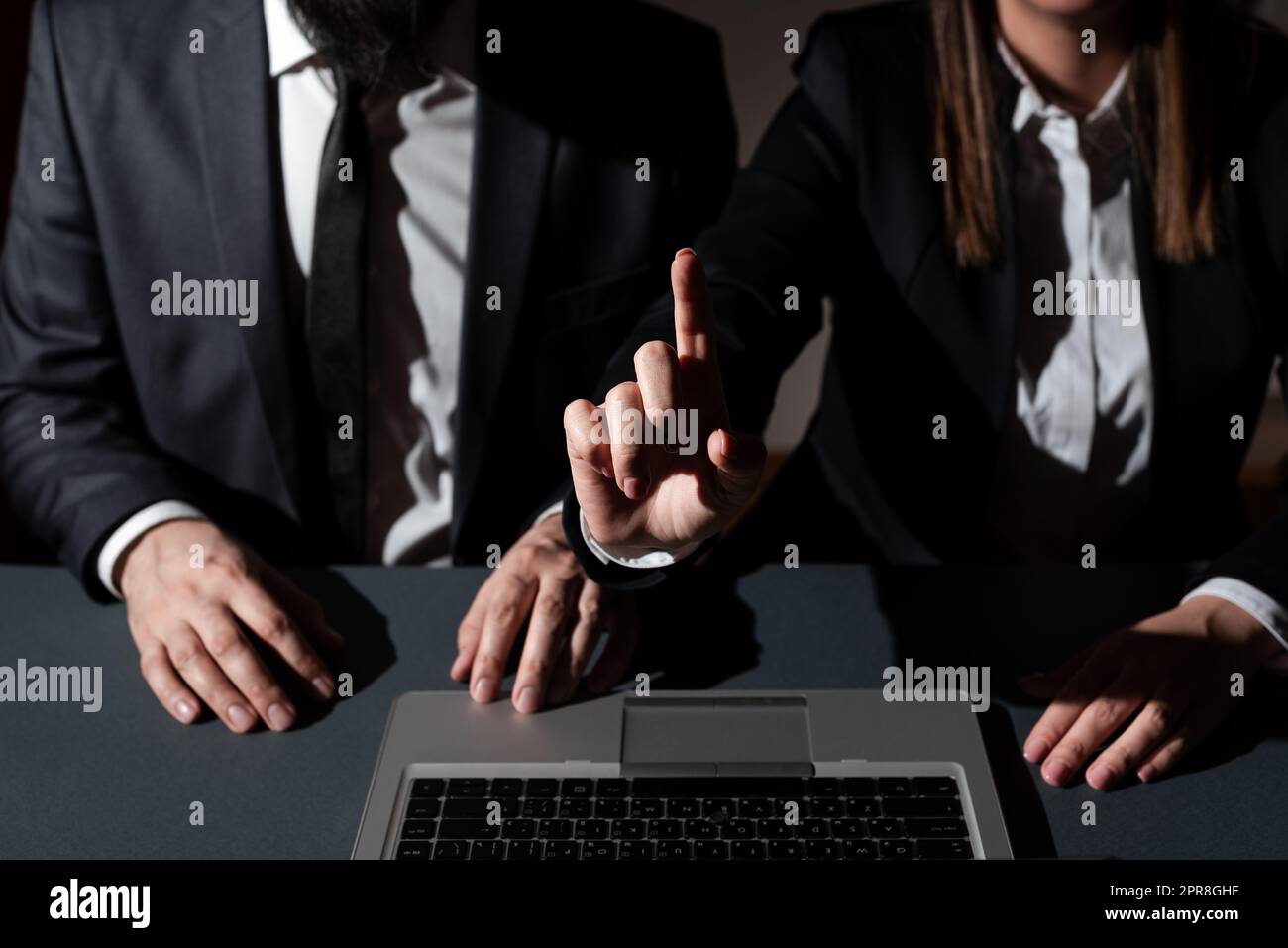 Homme assis sur le bureau avec le haut de la tour et femme pointant d'un doigt sur les messages importants. Femme d'affaires présentant des informations crutiales d'une main. Banque D'Images