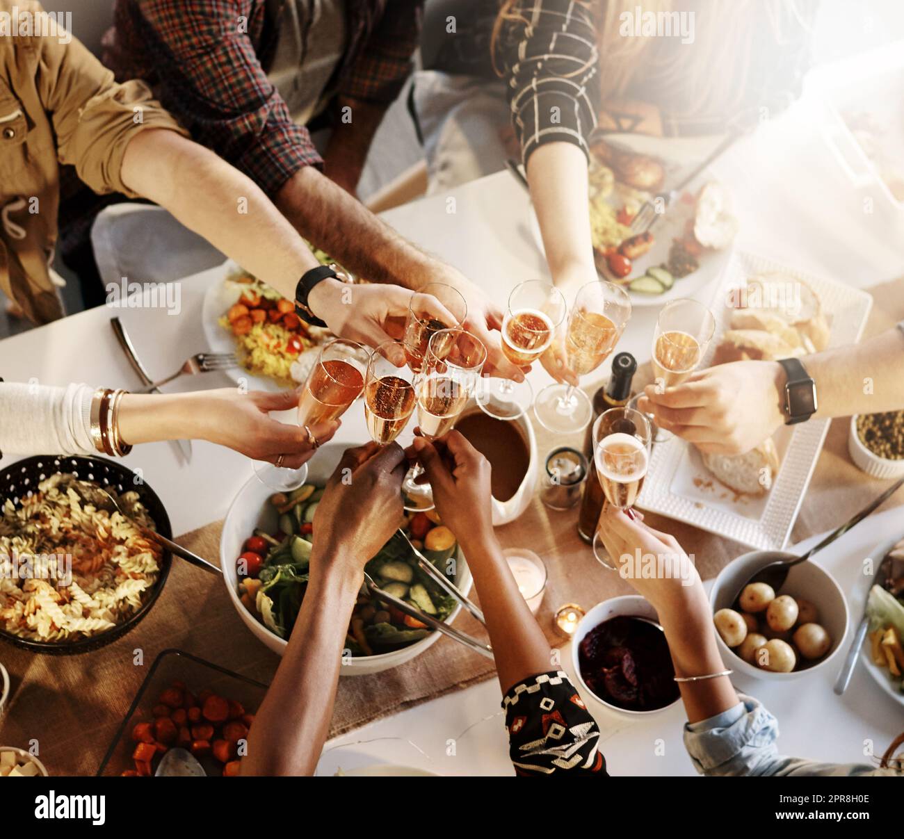 L'amitié est une bonne raison de célébrer. Un groupe de jeunes amis faisant un toast à un dîner. Banque D'Images