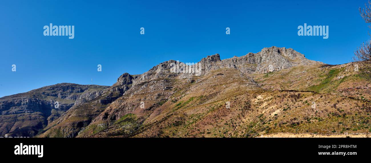 Douze Apôtres à la montagne de la Table, au Cap, sur un fond bleu ciel d'en-dessous. Vue à couper le souffle sur les plantes et les arbustes qui poussent autour d'une majestueuse vallée rocheuse et d'un site touristique pittoresque dans la nature Banque D'Images