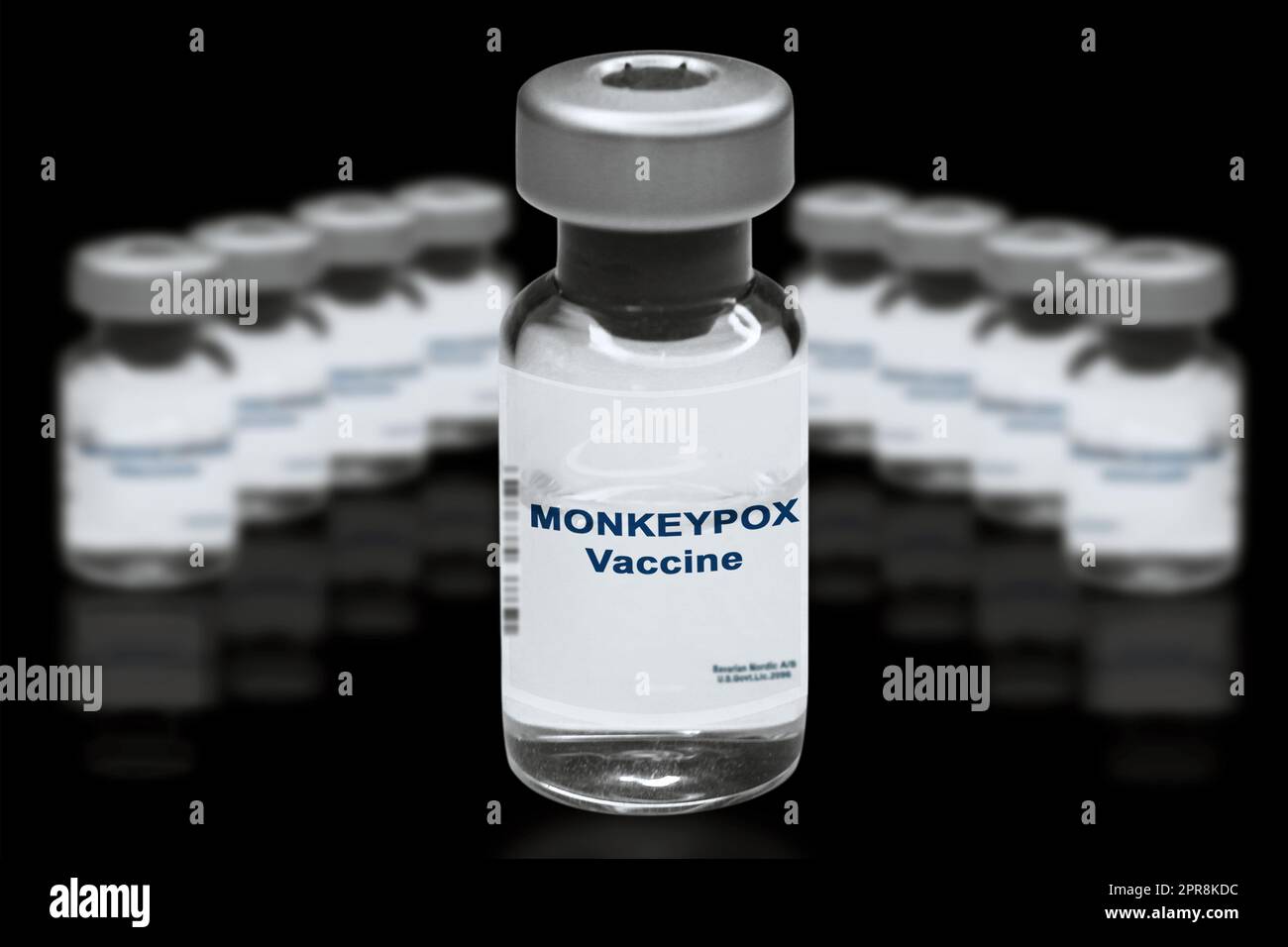Vaccin contre la variole du singe gros plan sur un fond noir miroir. À l'arrière-plan se trouvent des flacons de vaccins flous Banque D'Images
