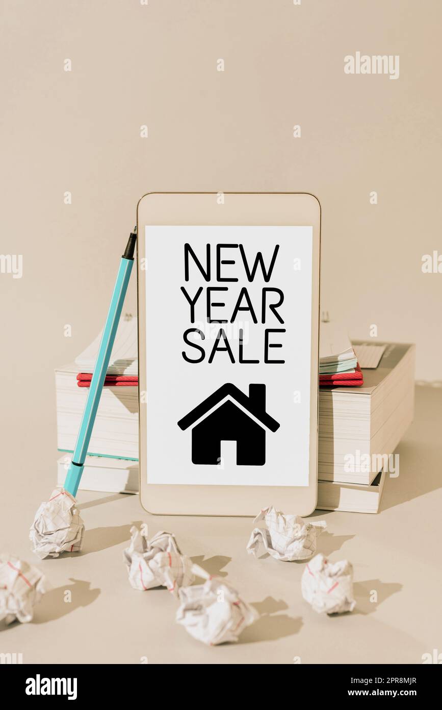 Écriture affichant le texte de la vente du nouvel an. Vitrine des affaires réductions finales de la période des fêtes réductions de prix Offres messages importants présentés sur téléphone mobile pencher sur les livres et les carnets. Banque D'Images