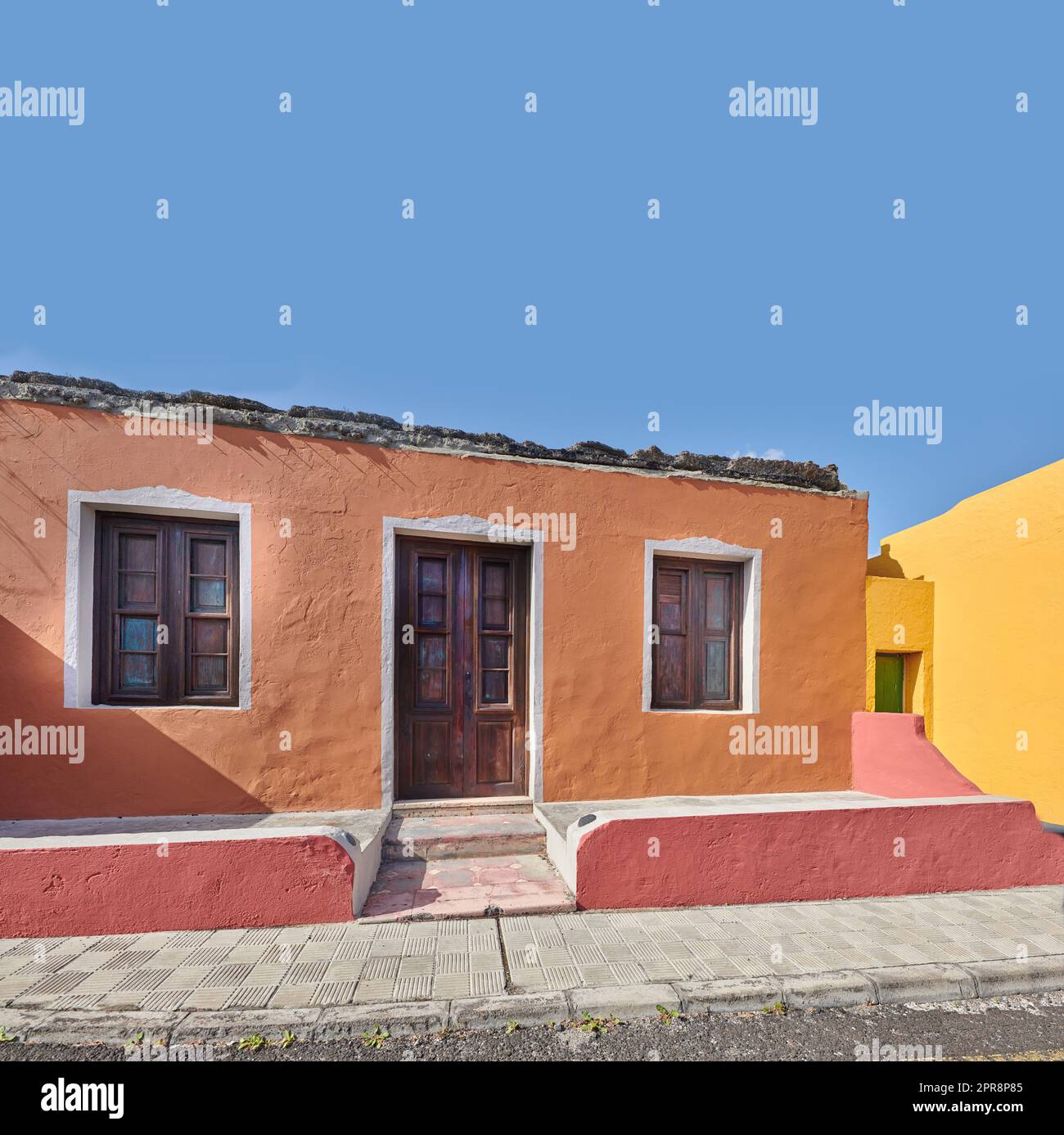 Bâtiment coloré dans une ville animée de Santa Cruz de la Palma avec ciel bleu clair copyspace fond sur une journée ensoleillée. Maisons résidentielles lumineuses dans un village d'une destination touristique populaire outre-mer Banque D'Images