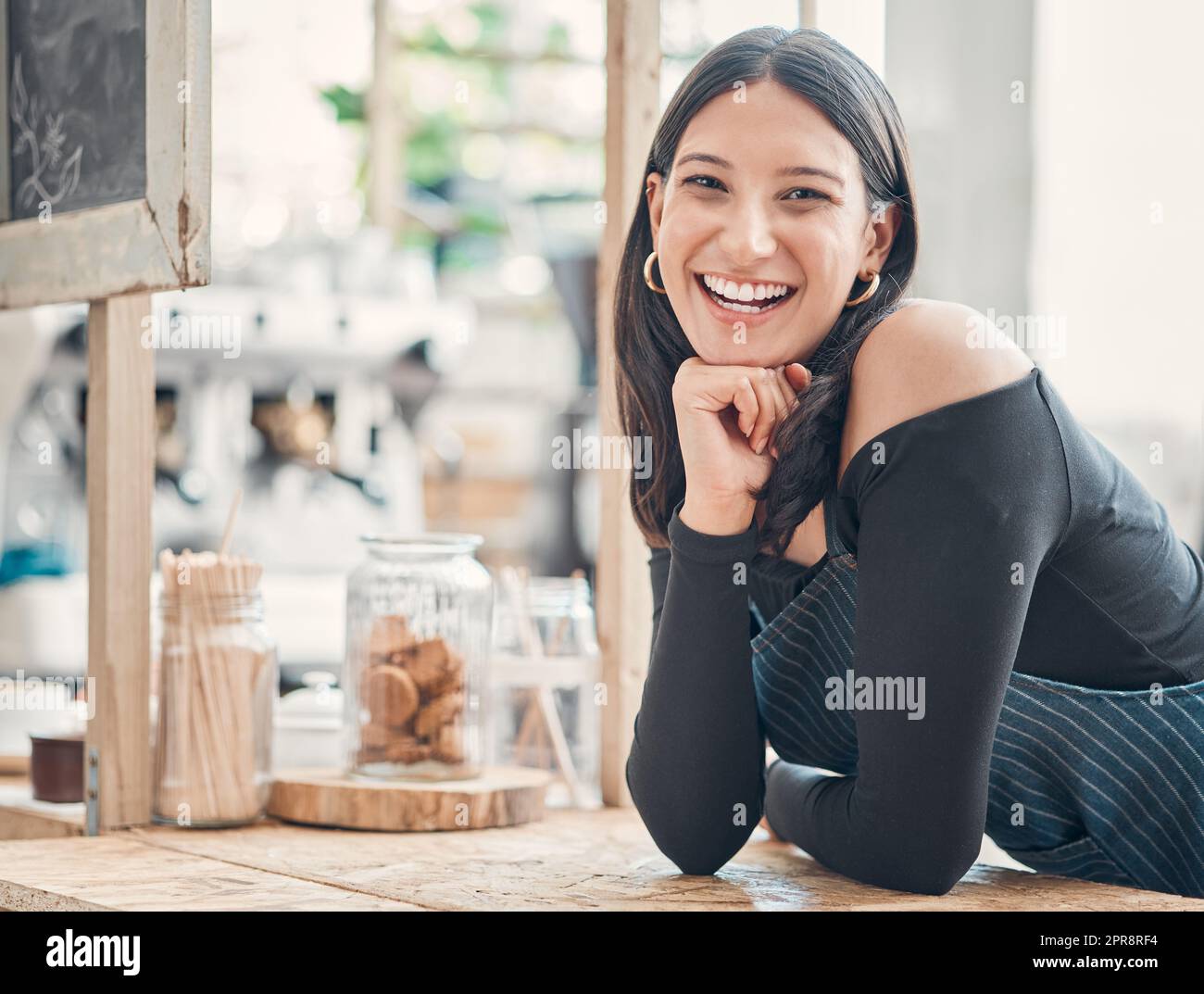 Portrait d'une jeune serveuse hispanique heureuse travaillant dans un magasin ou un café. Femme sympathique et propriétaire d'un café qui a réussi à démarrer un restaurant Banque D'Images
