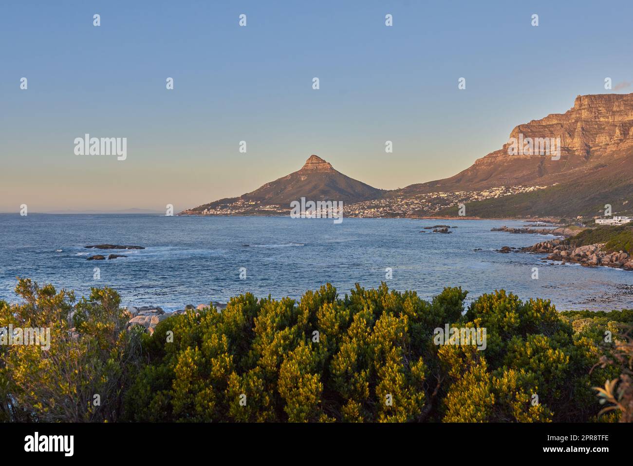 Panorama de la montagne de la Table et de la mer au coucher du soleil en Afrique du Sud. Paysage naturel pittoresque d'une côte à l'aube près d'un océan calme et paisible contre un horizon bleu avec espace de copie au Cap Banque D'Images