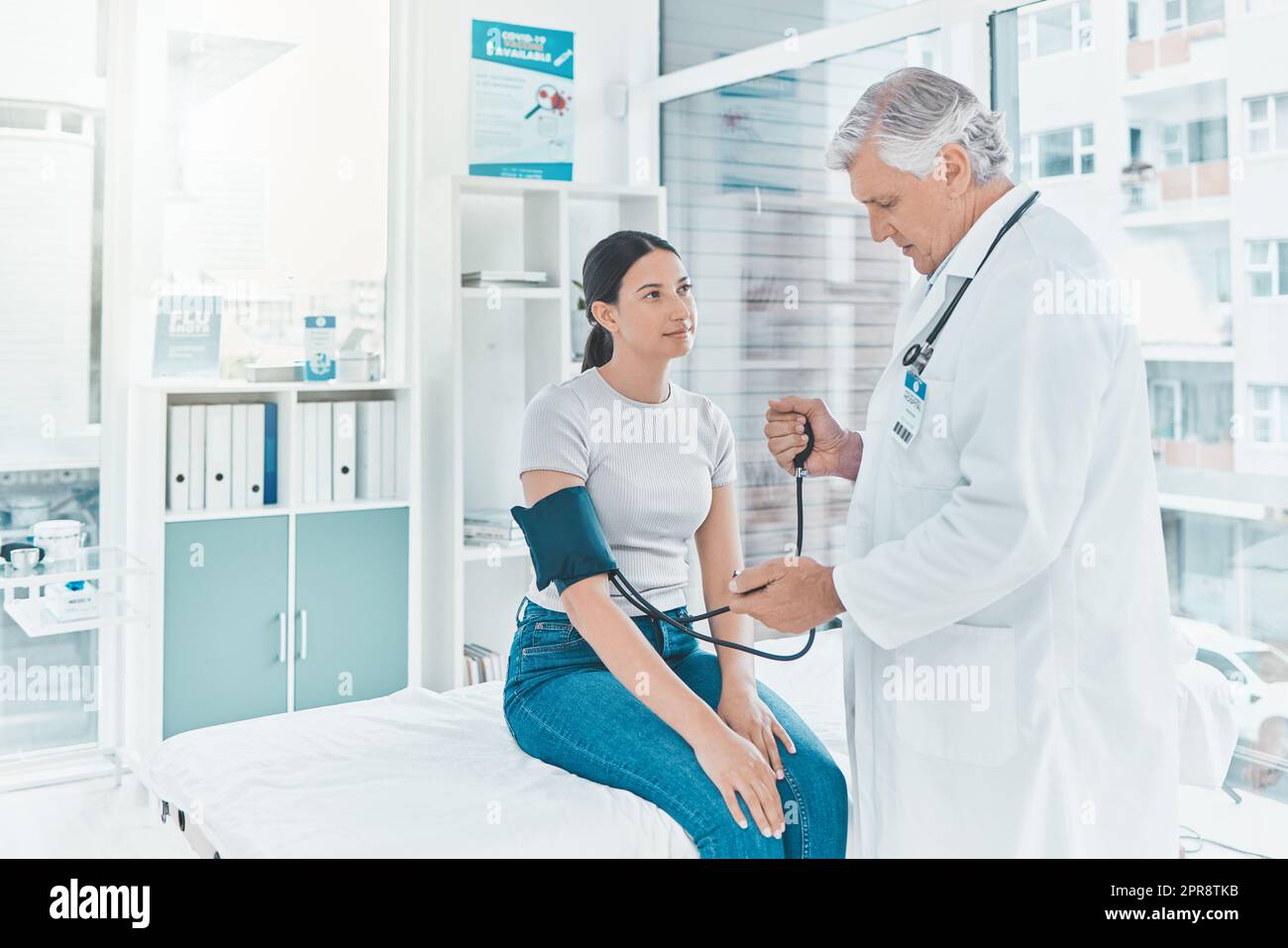 Vos chiffres me semblent bons. Un médecin mature vérifiant la tension artérielle d’un patient. Banque D'Images