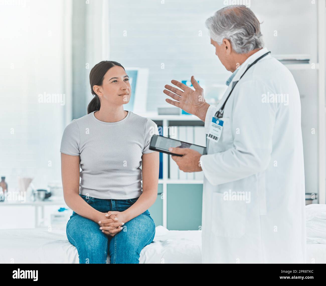 Le nouveau traitement est expérimental. Un médecin discutant des résultats d'un patient avec elle à l'aide d'un comprimé numérique. Banque D'Images