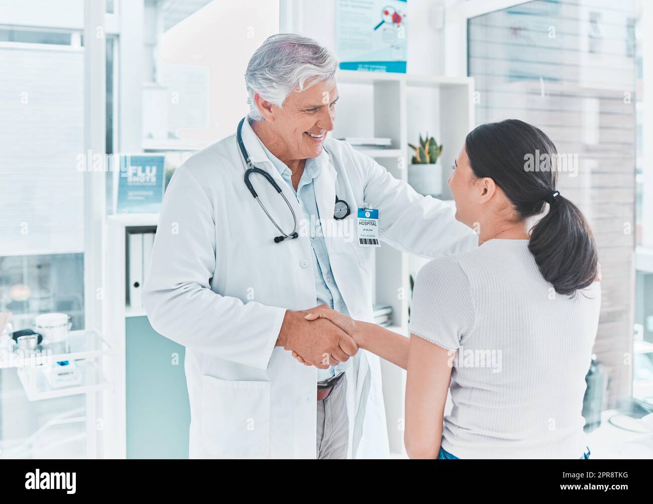 Comment puis-je vous aider. Un médecin senior se secouant la main avec un patient en saluant. Banque D'Images