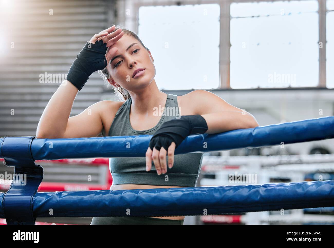 Athlète de fitness féminine confiante, active et tonifiée dans un ring de boxe après un combat, un match ou une séance de sparring dans une salle de sport. Une femme en bonne santé, en forme et forte prête à faire de l'exercice, de l'exercice et de l'entraînement Banque D'Images