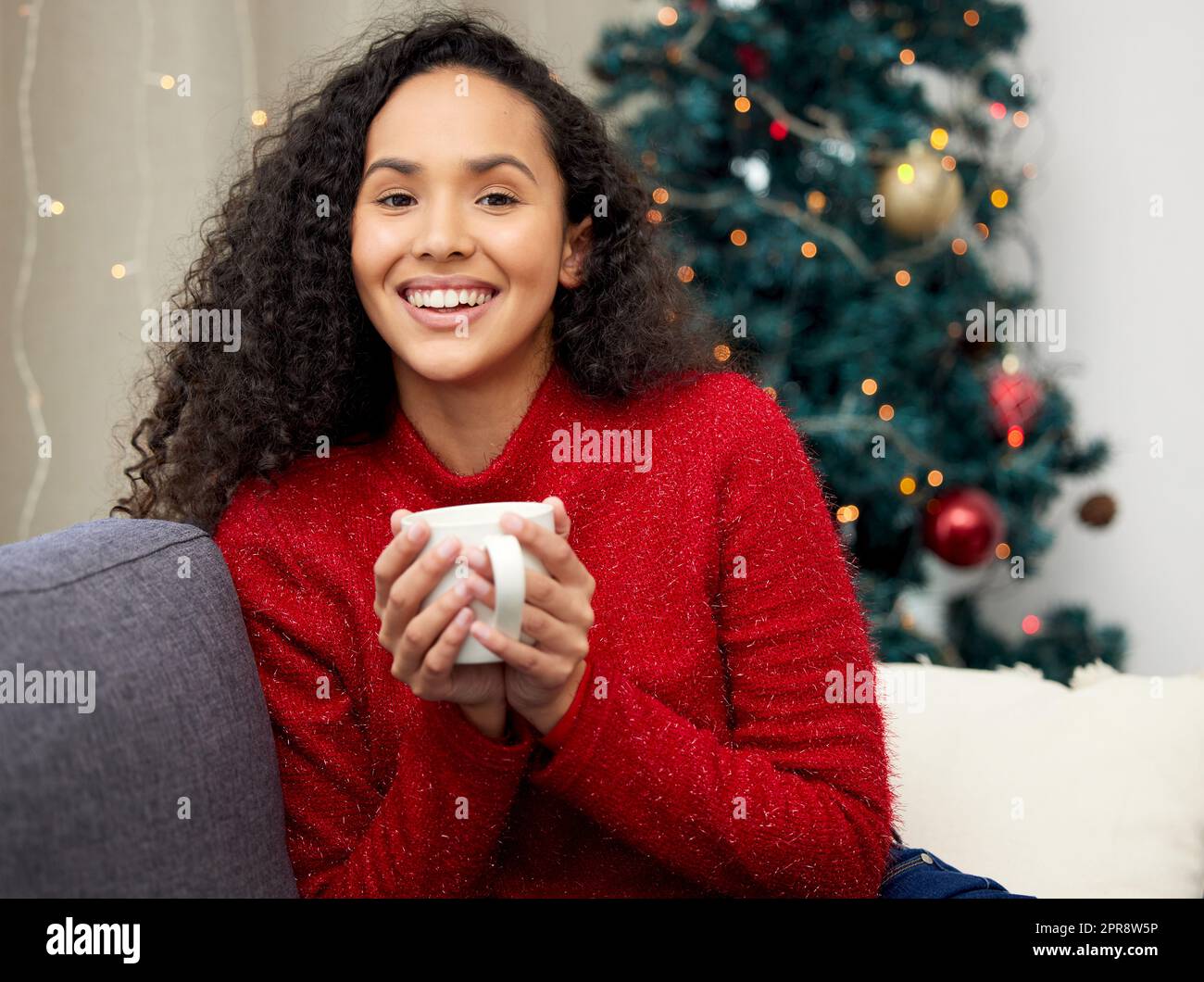 Juste parce que je ne peux pas le voir ne veut pas dire que je ne peux pas le croire. Une jeune femme qui boit du café sur le canapé à la maison. Banque D'Images