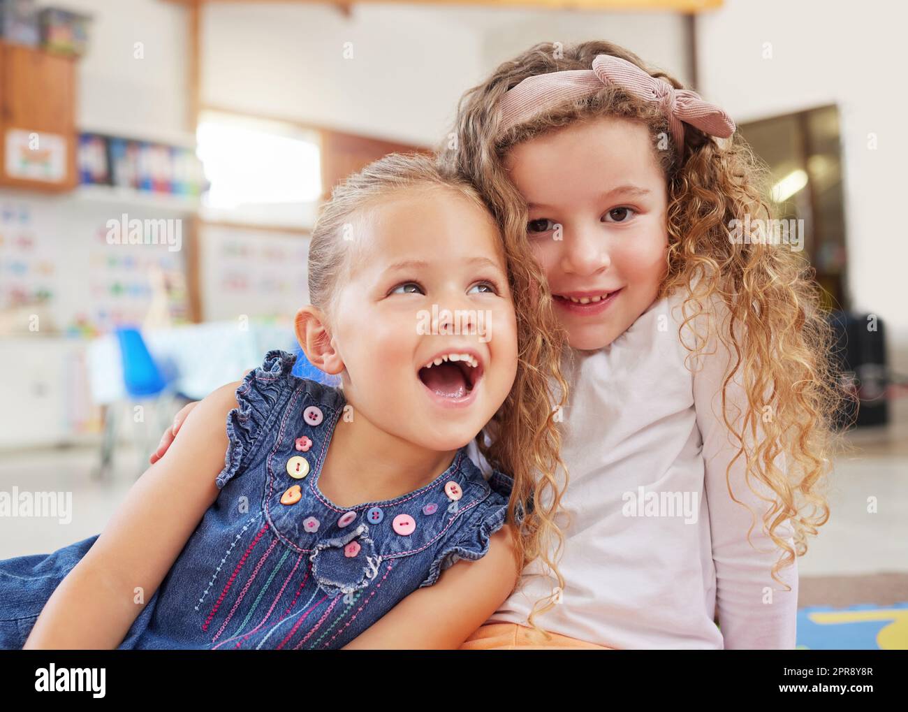 C'est mon nouvel ami. Deux petites filles assises l'une à côté de l'autre en classe. Banque D'Images