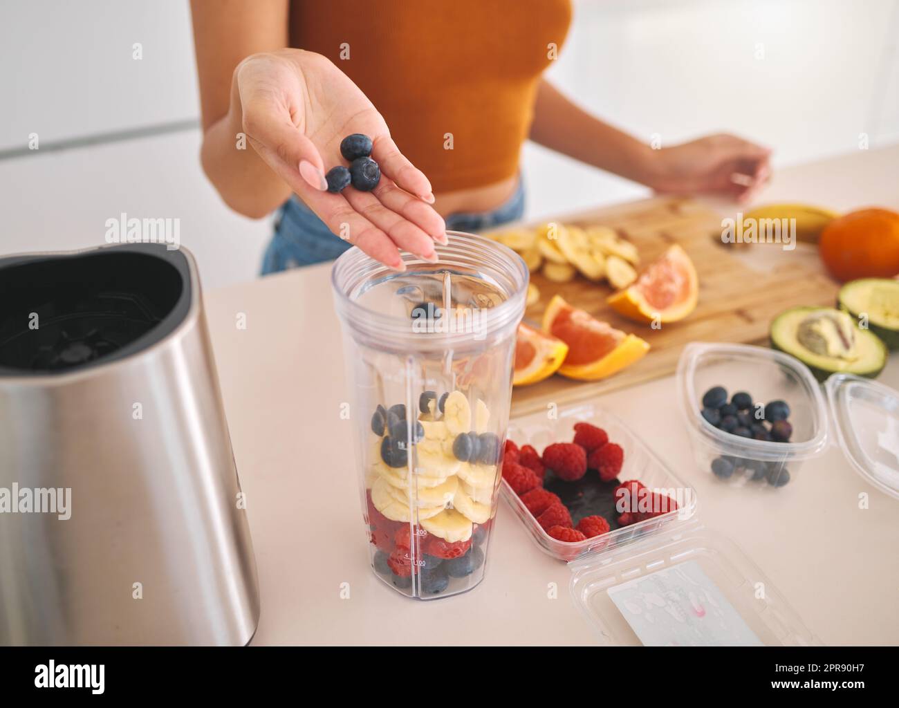 Cela va être délicieux de baies. Une femme mettant une variété de fruits dans un mélangeur à la maison. Banque D'Images