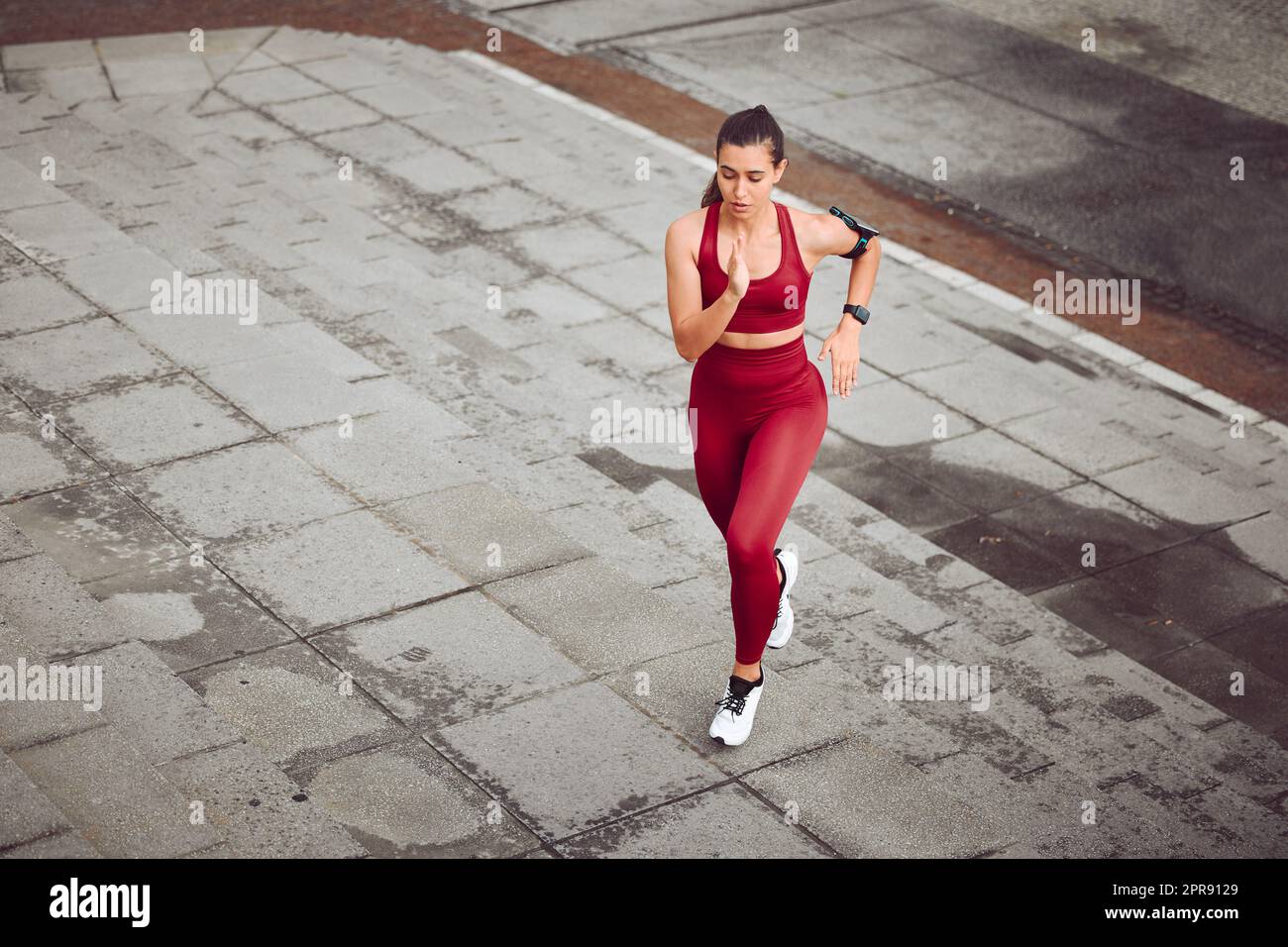 Son niveau de forme physique est en hausse. Photo en grand angle d'une jeune athlète féminine attirante qui court en plein air. Banque D'Images