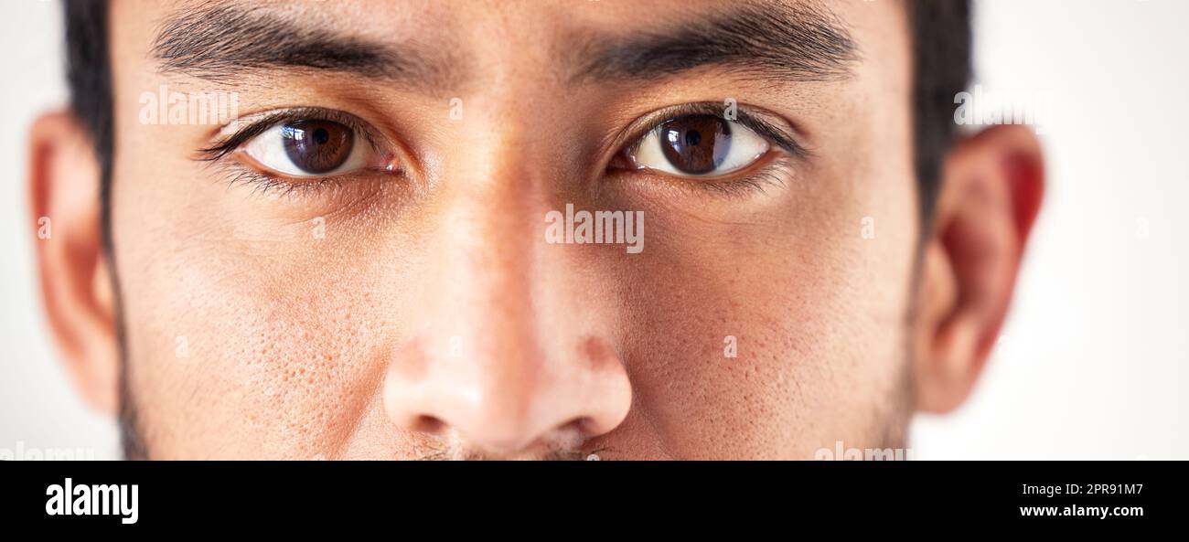 Gros plan d'un homme asiatique inconnu visage et les yeux regardant vers l'avant et dans la caméra. Zoom tête d'un homme de course mixte qui regarde et regarde devant. Des yeux sains pour une optique et une vision claires Banque D'Images