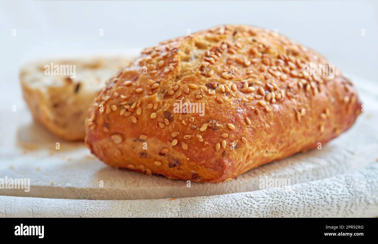 Nourriture. Un pain frais maison de blé entier ou de blé entier, pain de graines de sésame sur une planche, prêt à être coupé. Pour un régime et un mode de vie sains, mangez des aliments riches en fibres. Banque D'Images