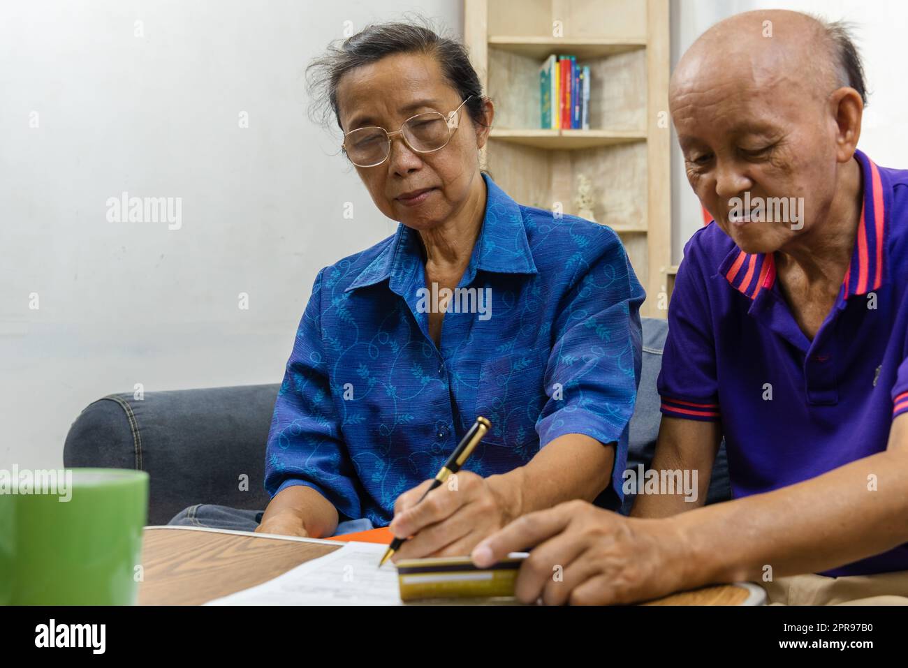 Asie personnes âgées holding stylo contrat paiement carte de crédit assurance santé paperasse ou document rapport shopping finance concept. Banque D'Images