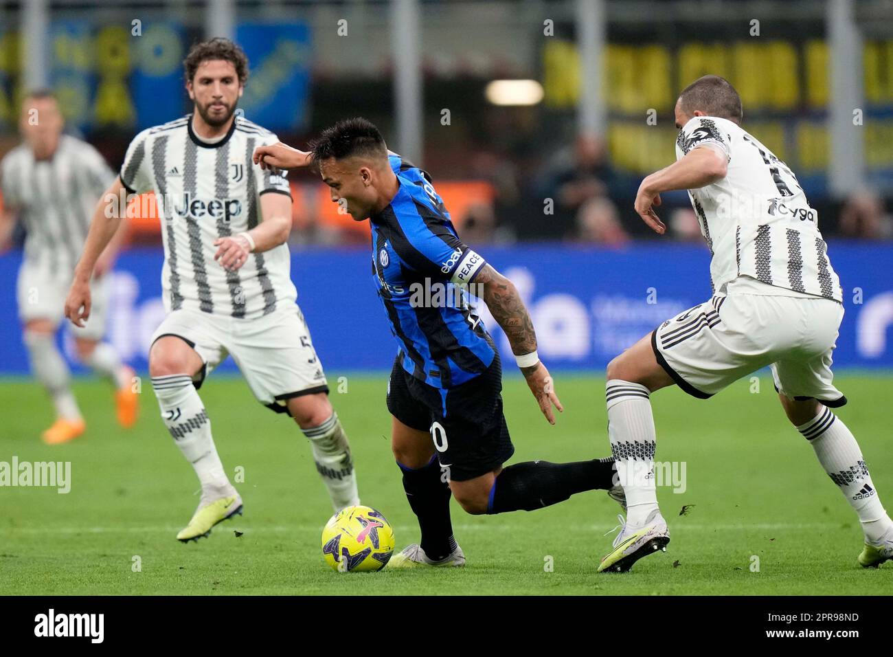 Inter Milan's Lautaro Martinez, center, Juventus' Manuel Locatelli, background, and Juventus' Leonardo Bonucci challenge for the ball during a Italian cup semi final second leg soccer match between Inter Milan and Juventus at the San Siro stadium in Milan, Italy, Wednesday, April 26, 2023. (AP Photo/Luca Bruno) Banque D'Images