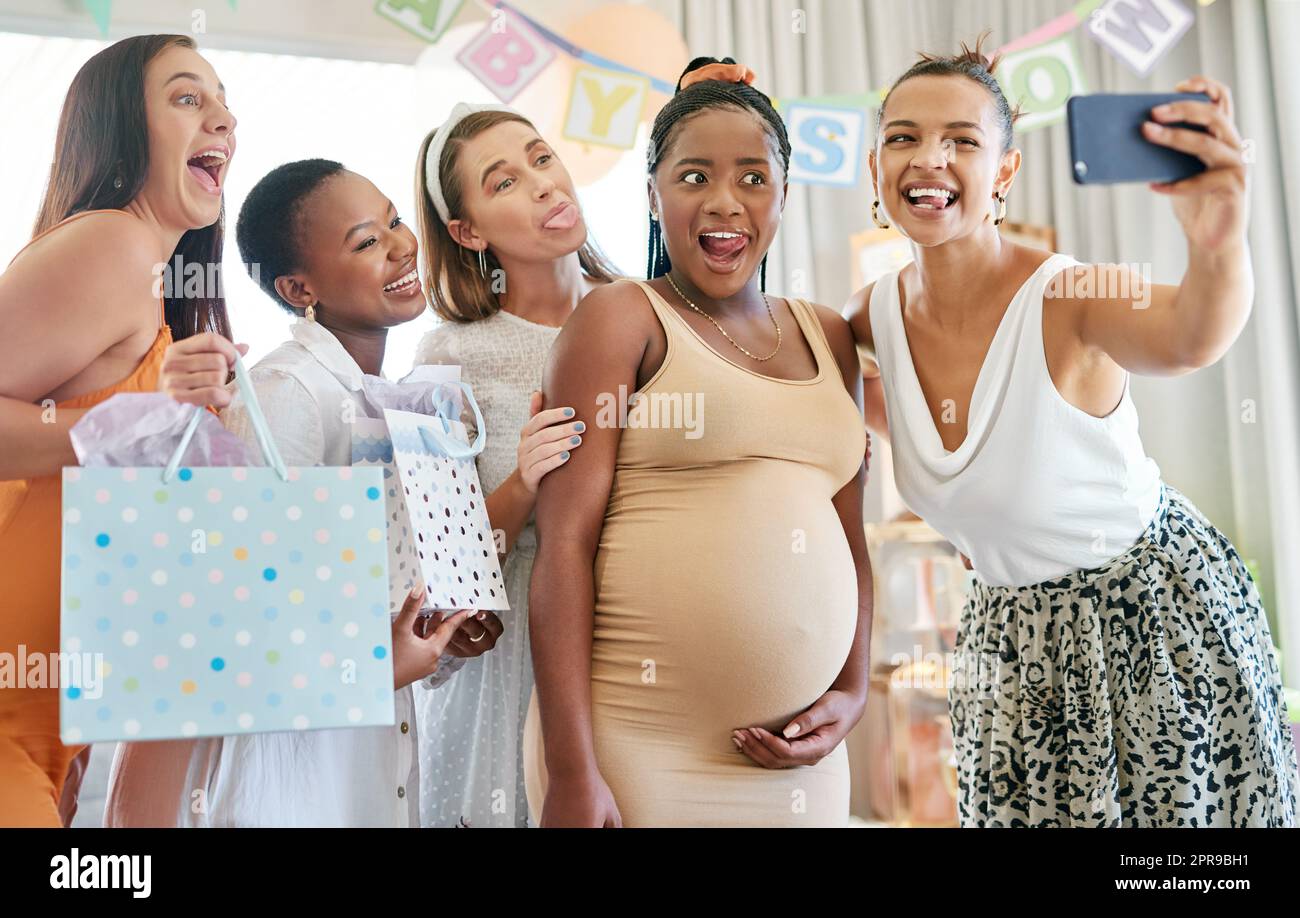 Je ne me souviens pas de ce jour pour toujours. Un groupe d'amis féminins prenant des selfies à une douche de bébé. Banque D'Images