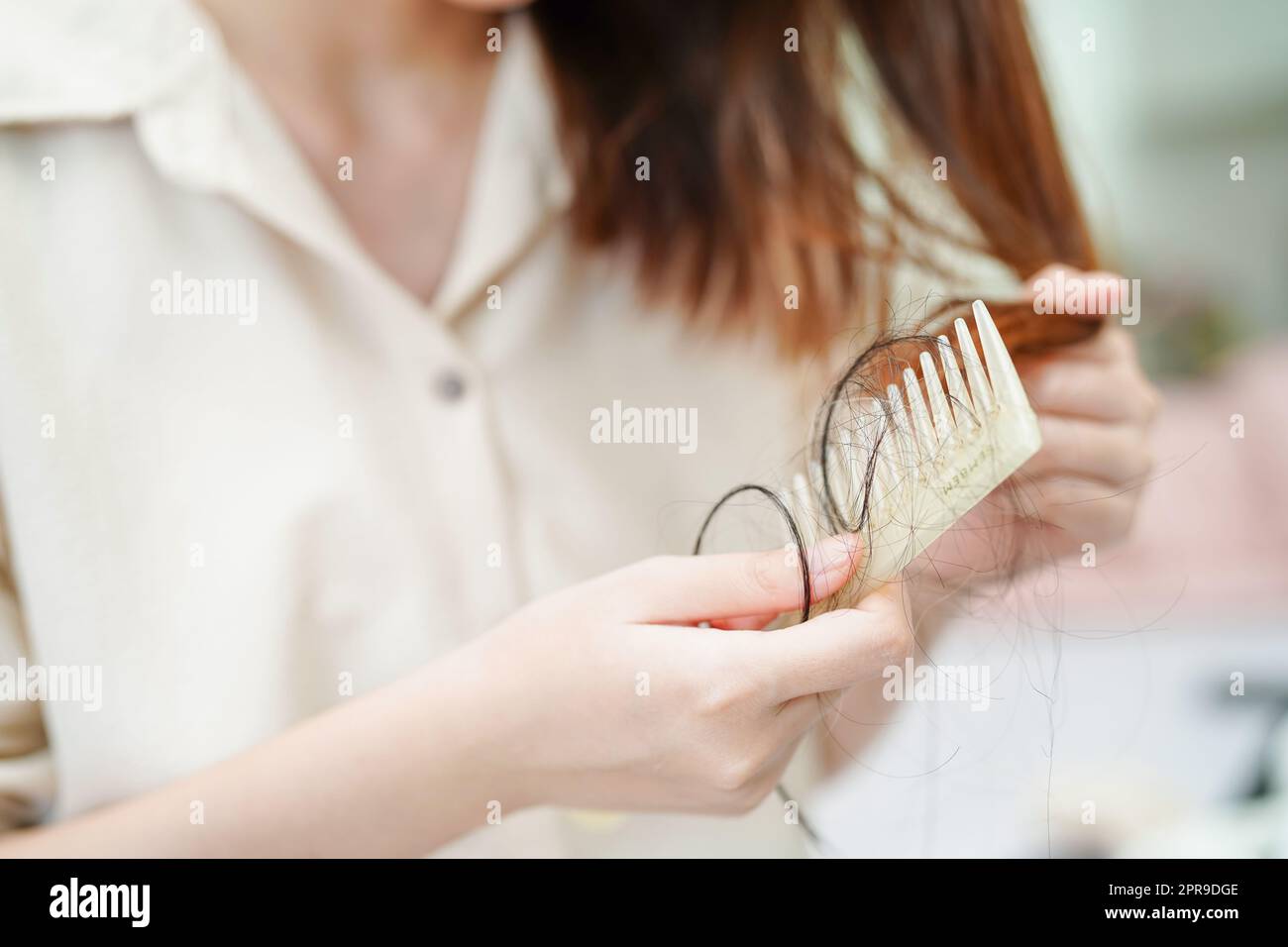 Femme asiatique ont des problèmes avec la perte de cheveux longue attacher à la brosse de peigne. Banque D'Images