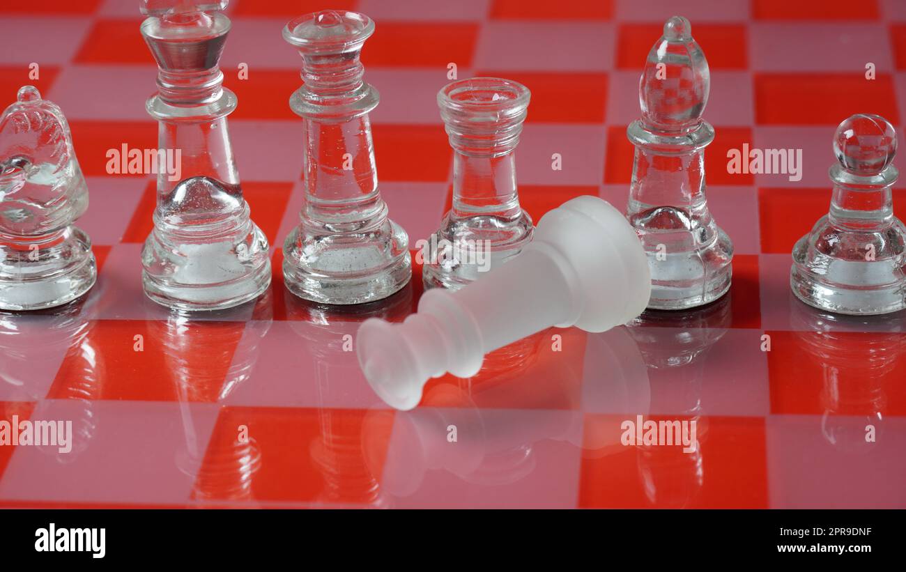 Figures d'échecs transparentes, sur la position de départ, sur le plateau d'échecs réfléchissant, ton rouge. Jeu de plateau d'échecs stratégiques Banque D'Images