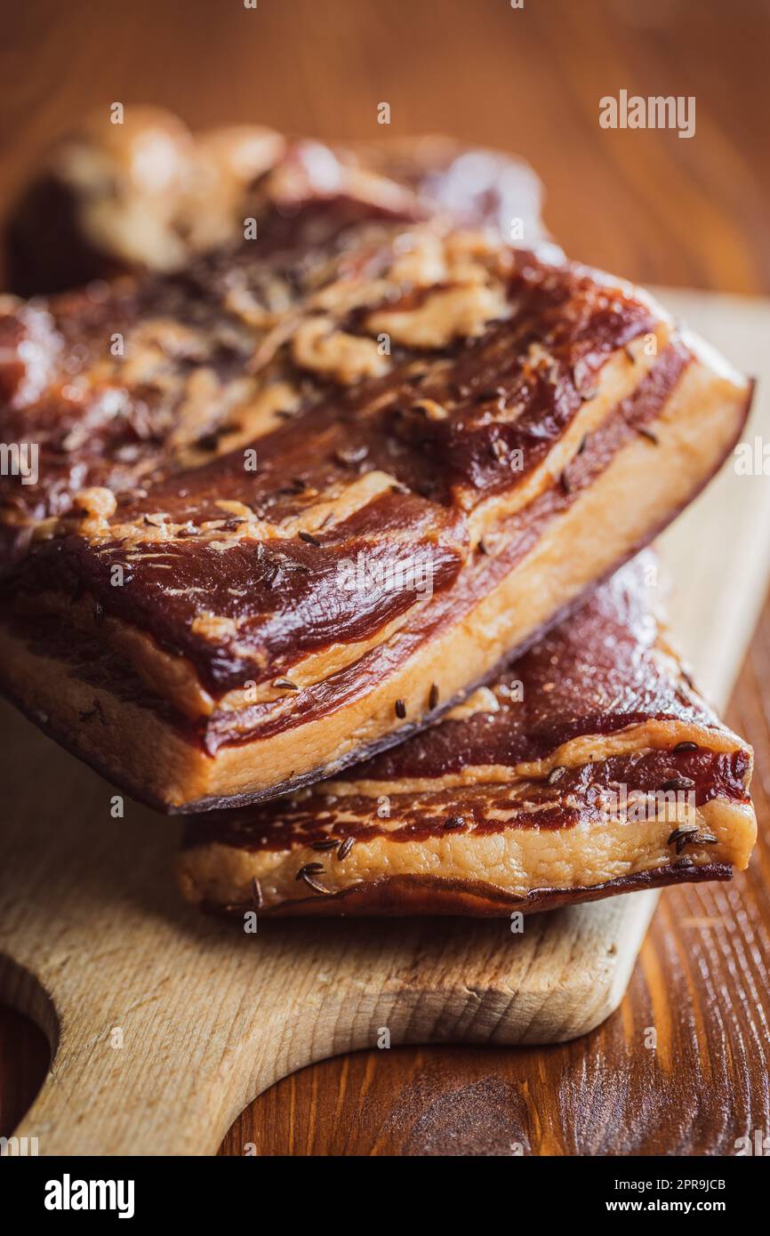 Bacon fumé entier sur la planche à découper. Banque D'Images