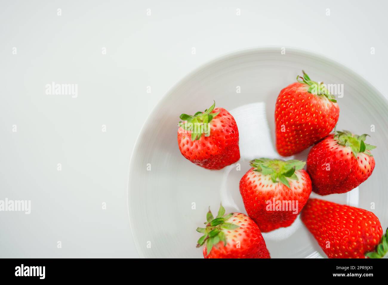 Des fraises fraîches et des plats blancs Banque D'Images