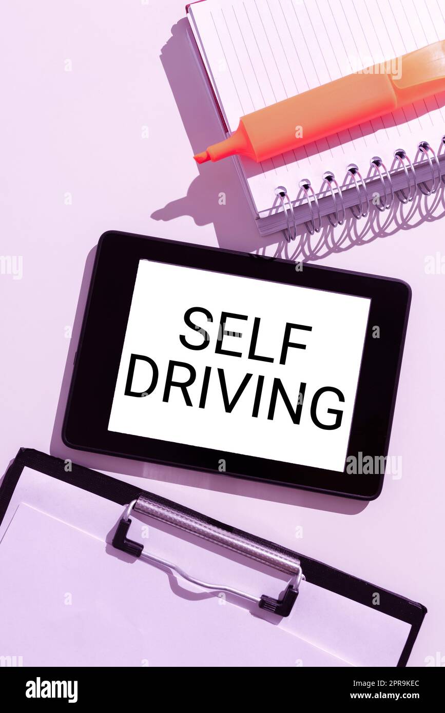 Inspiration montrant le signe de conduite autonome. Concept commercial véhicule autonome capacité à naviguer sans intervention humaine tablette avec message important entre le presse-papiers, le bloc-notes et le marqueur. Banque D'Images