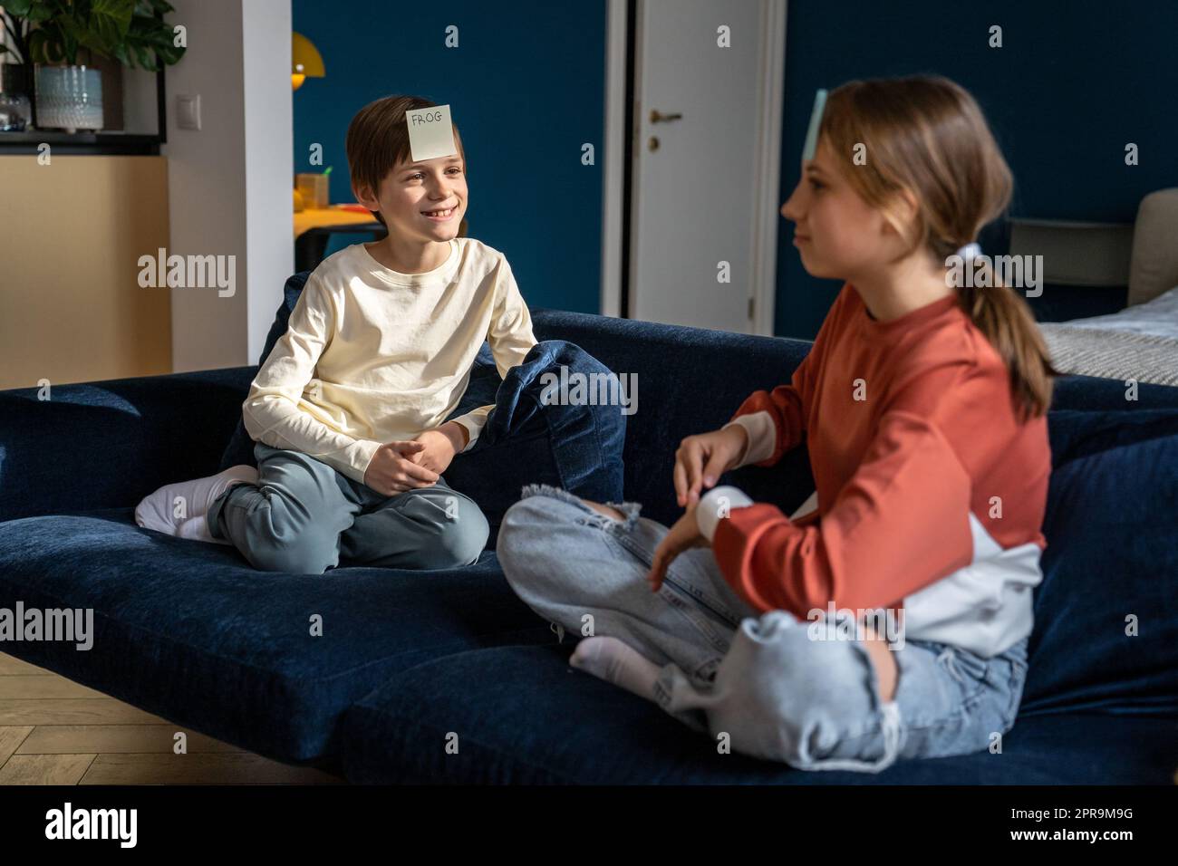 Deux enfants frère et soeur jouant à devinettes jeu qui suis moi à la maison Banque D'Images