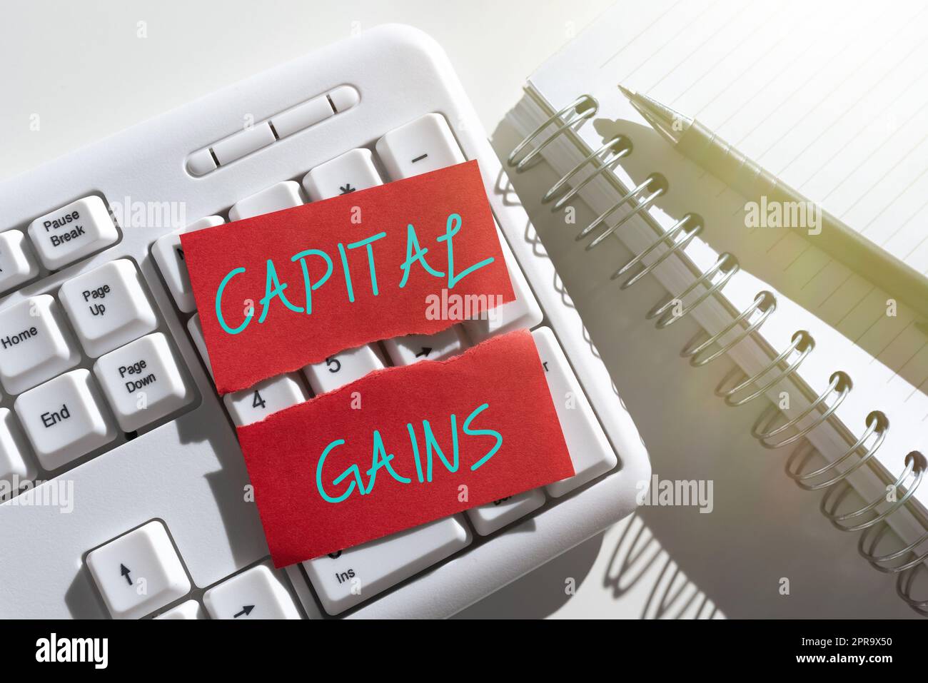Signe de texte indiquant les gains en capital. Word for Bond actions actions Fonds d'investissement de l'impôt sur le revenu des bénéfices Note déchirée avec des messages importants au-dessus du clavier sur le bureau avec des carnets. Banque D'Images