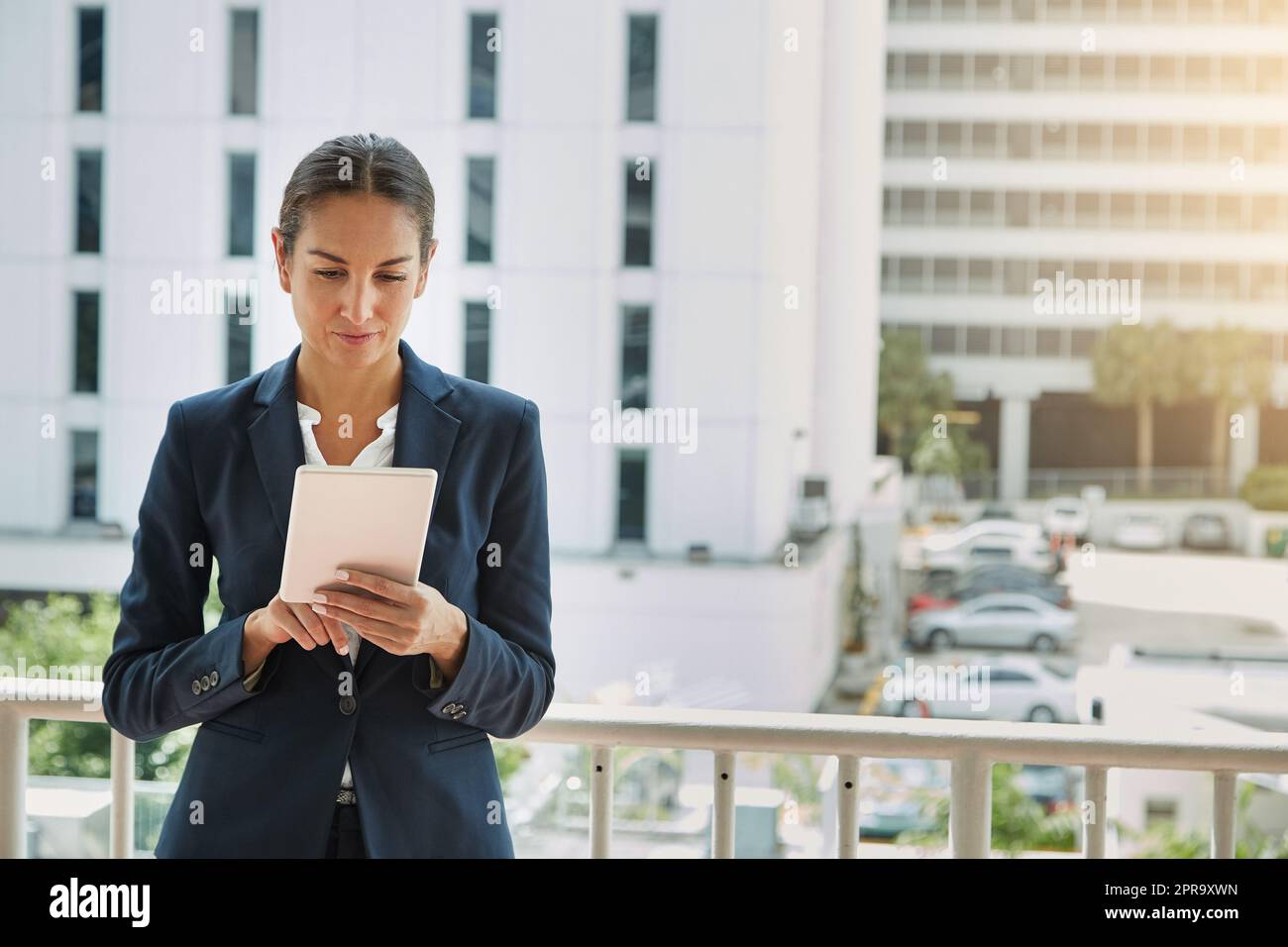 Mise en ligne de son entreprise. une jeune femme d'affaires utilisant une tablette numérique sur son chemin au bureau. Banque D'Images
