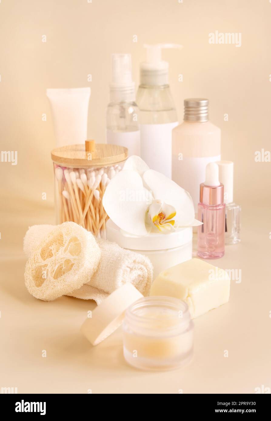 Pots cosmétiques naturels et accessoires pour le soin de la peau avec fleur d'orchidée blanche sur l'espace de copie jaune clair Banque D'Images