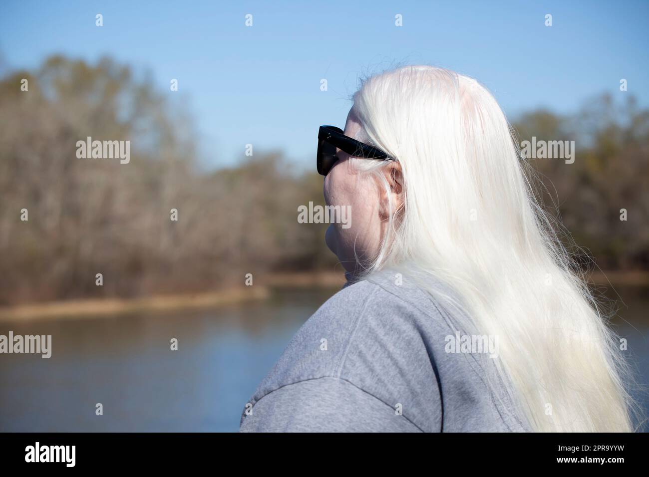 Femme aux cheveux blancs près d'un lac Banque D'Images