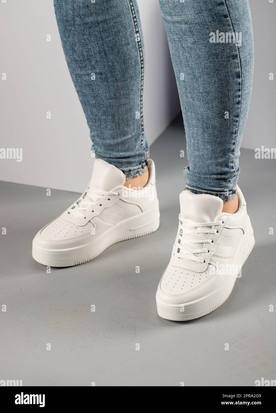Baskets blanches confortables et décontractées sur une mannequin en studio. Banque D'Images Baskets blanches confortables et décontractées sur une mannequin en studio. Banque D'Images