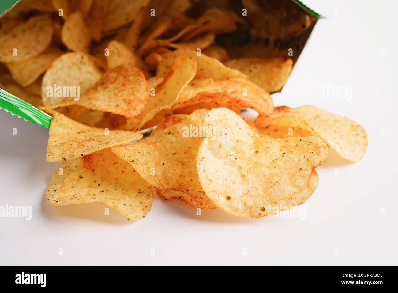 Croustilles dans un sac ouvert, délicieux assaisonnement barbecue épicé pour les pleurs, fine tranche d'en-cas frits dans un sac ouvert. Banque D'Images