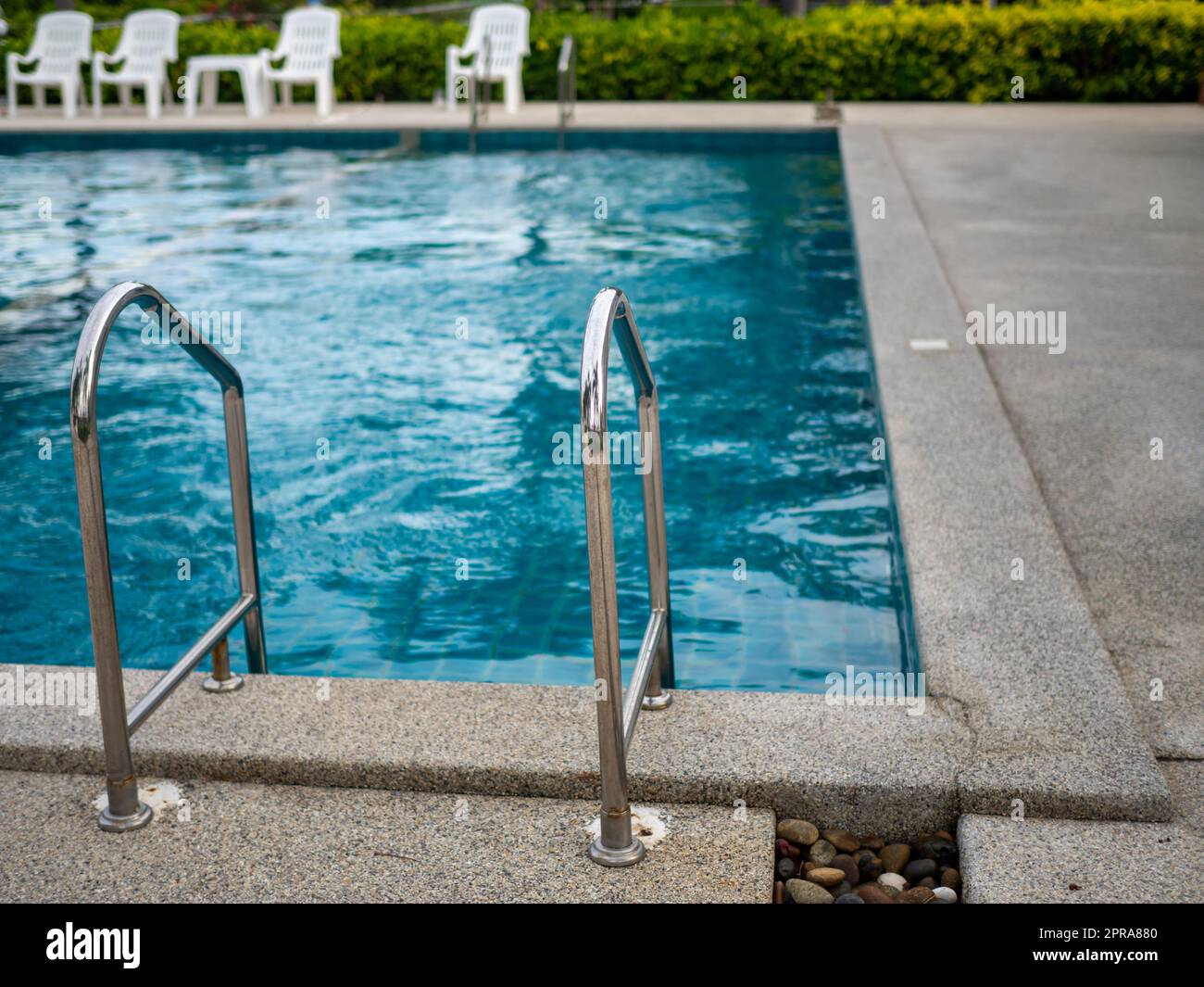 .Escalier en acier inoxydable vers la piscine. mains courantes de haut en bas de la piscine. Banque D'Images