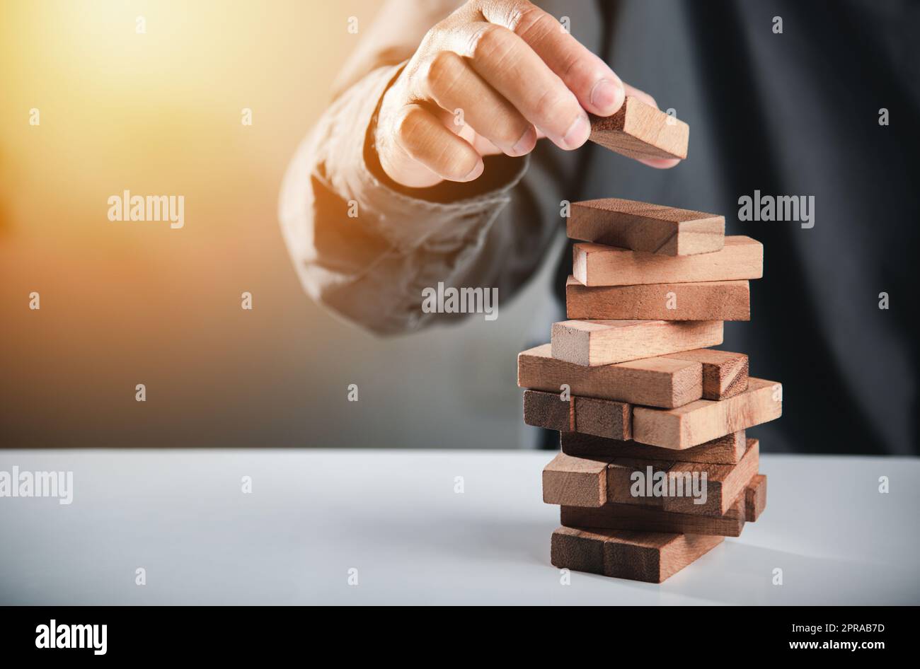 Main d'affaires jouant tour jeu de blocs en bois Banque D'Images