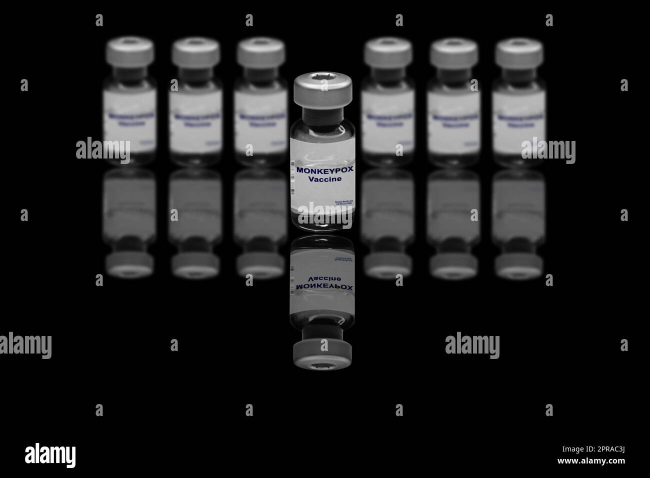 Vaccin contre la variole du singe gros plan sur un fond noir miroir. À l'arrière-plan se trouvent des flacons de vaccins flous Banque D'Images