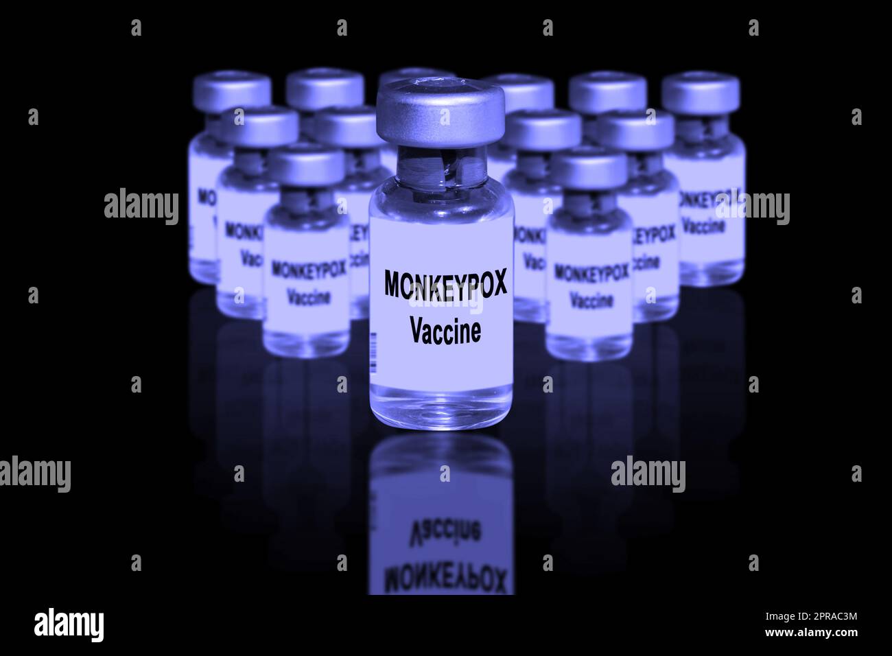 Vaccin contre la variole du singe gros plan sur un fond noir miroir. À l'arrière-plan se trouvent des flacons de vaccins flous Banque D'Images