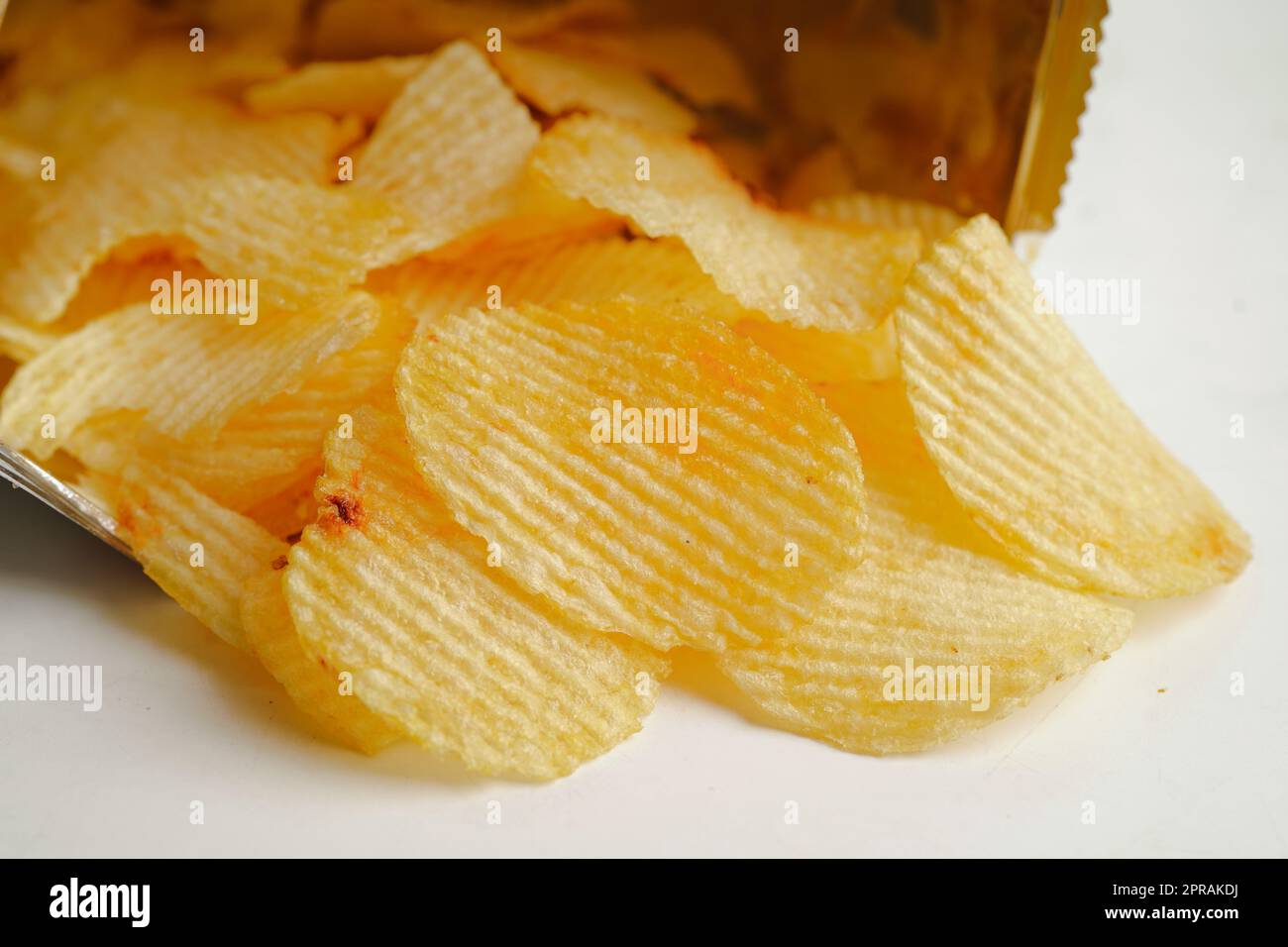 Croustilles dans un sac ouvert, délicieux assaisonnement barbecue épicé pour les pleurs, fine tranche de collation frite rapide. Banque D'Images