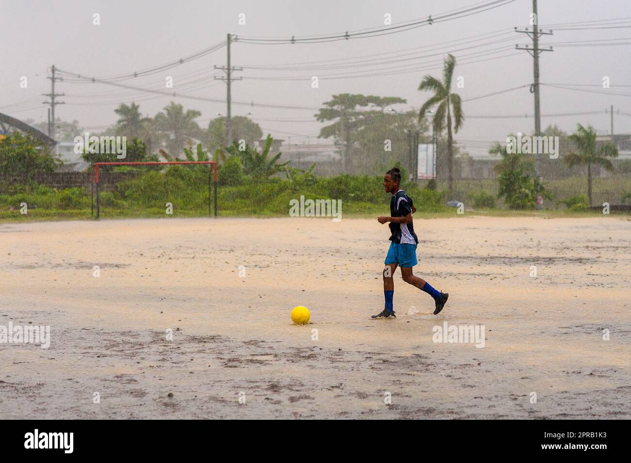 Un jeune joueur de football afro-colombien participe à une session d'entraînement lors d'une tempête tropicale à Quibdó, Chocó, Colombie. Banque D'Images