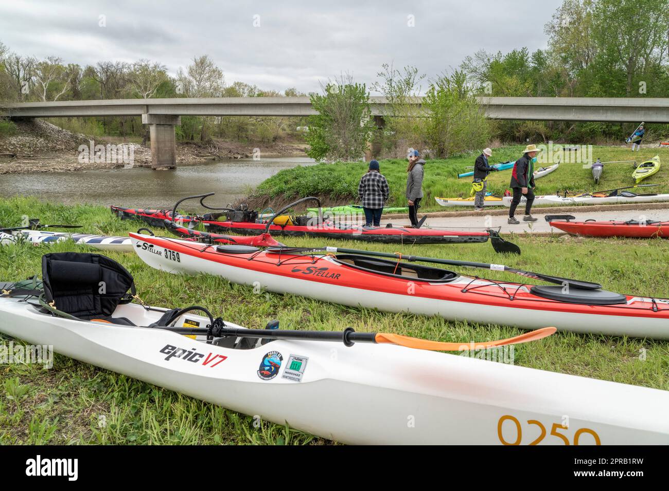 Lamine, Mo, Etats-Unis - 22 avril 2023: Pagayeurs et bateaux (kayaks, canoë-outrigger, surf) sur une rive de la rivière Lamine en paysage printanier. Banque D'Images