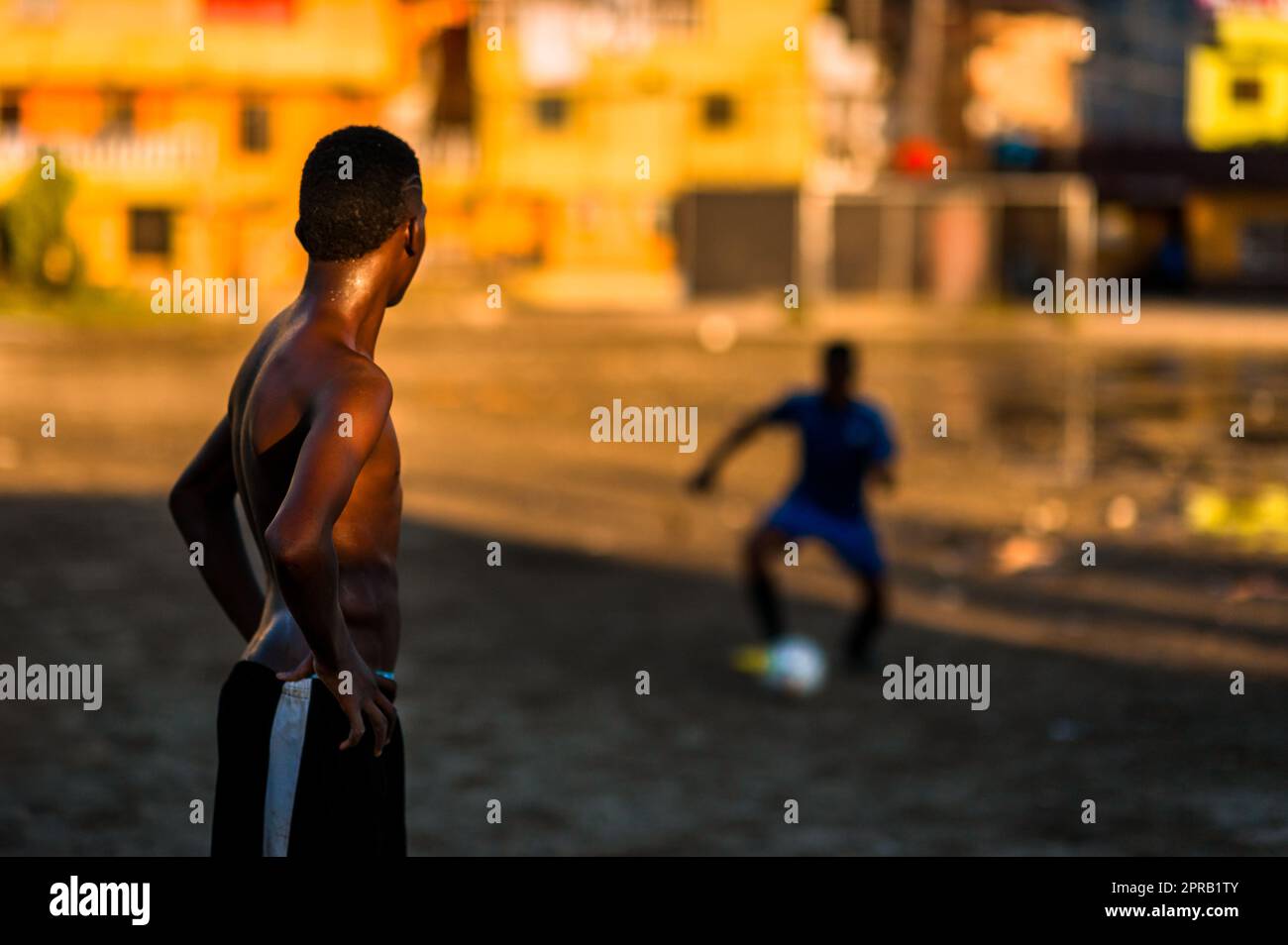 Un jeune joueur de football afro-colombien pratique le contrôle du ballon lors d'une séance d'entraînement sur un terrain de jeu de terre à Quibdó, Chocó, Colombie. Banque D'Images